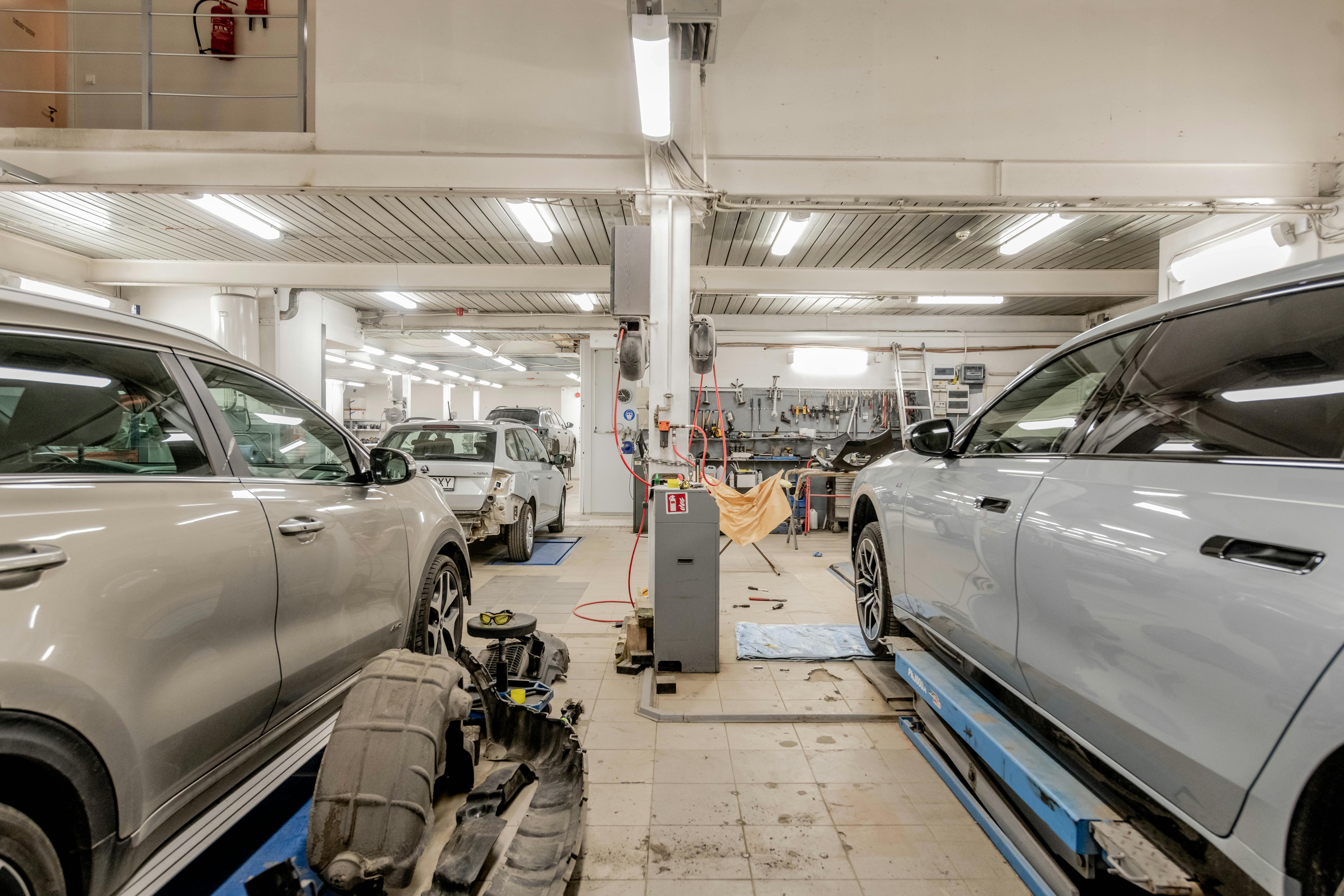 Modern workshop service bays with vehicles prepared for electrical diagnostics.