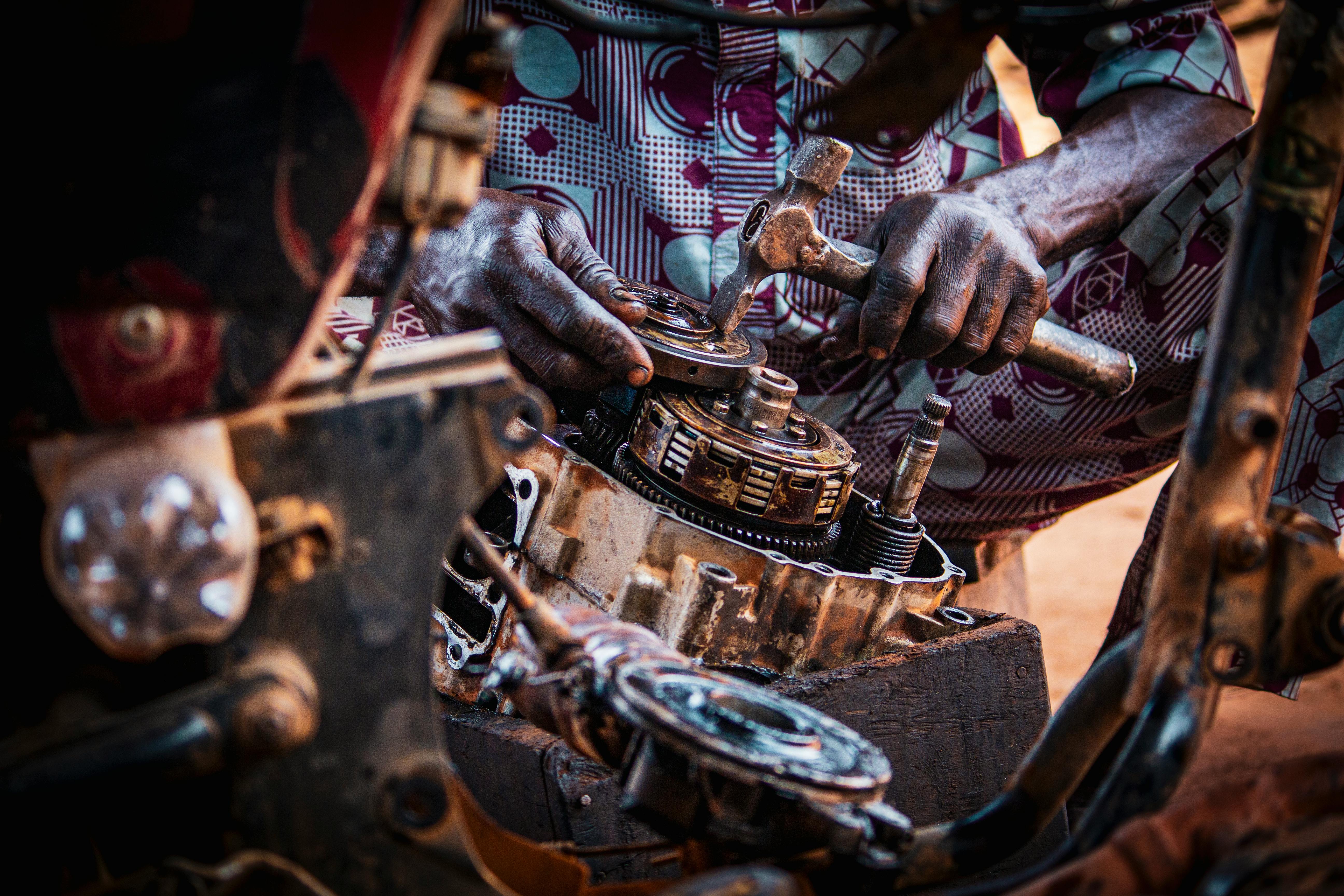 Mechanic hands repairing an engine-bay component after diagnosis.